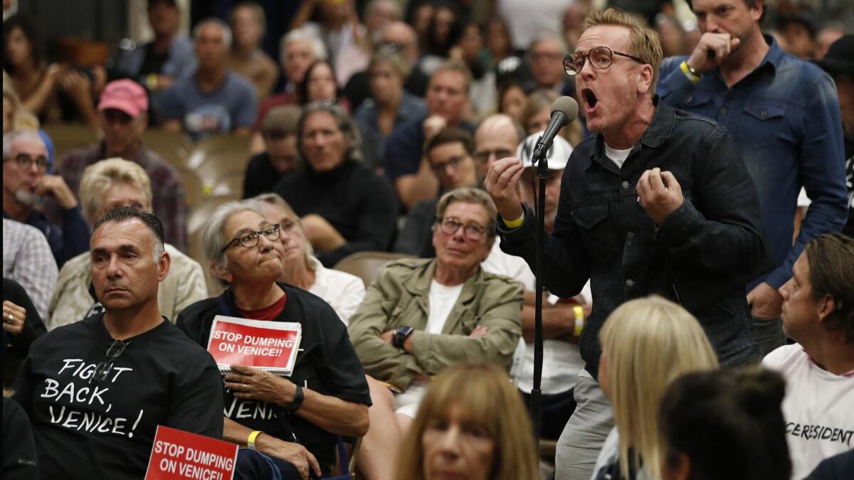 Anthony Wells, right, voices his opposition to Mayor Eric Garcetti, Councilman Mike Bonin and LAPD Police Chief Michel Moore during a town hall at Westminster Elementary School in Venice, Calif. on Oct. 17.
