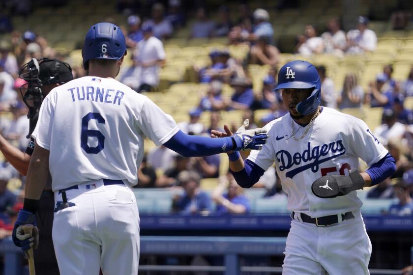 Los Angeles Dodgers' Mookie Betts, right, is congratulated by Trea Turner after scoring on a single by Freddie Freeman during the first inning of a baseball game against the Arizona Diamondbacks Wednesday, May 18, 2022, in Los Angeles. (AP Photo/Mark J. Terrill)
