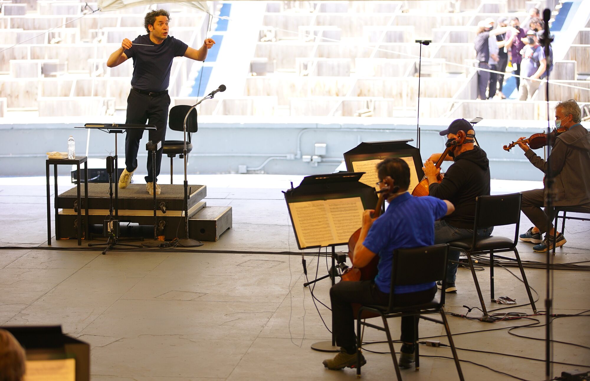 Dudamel holds up his hands as he conducts rehearsal