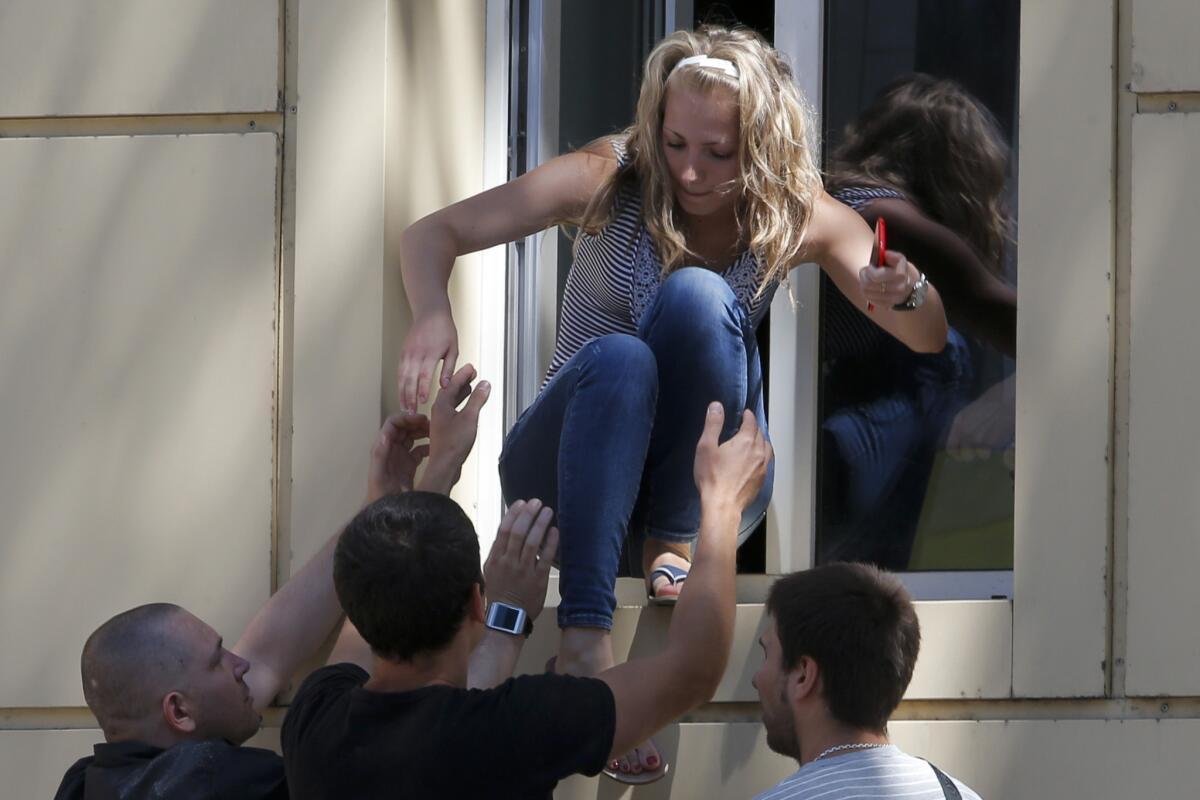 A woman evacuates from a hospital in downtown Donetsk, eastern Ukraine, as fighting rages July 1 at a nearby police building.