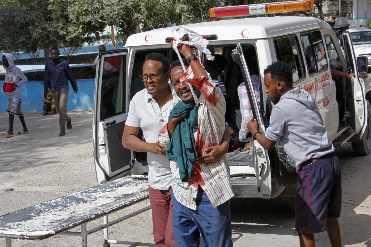 Un hombre ayuda a otro herido por la explosión de una bomba