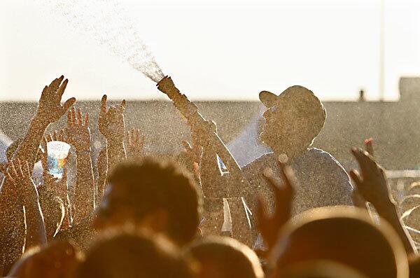 A man opens a hose to cool concert-goers Saturday at the Epicenter festival in Fontana.