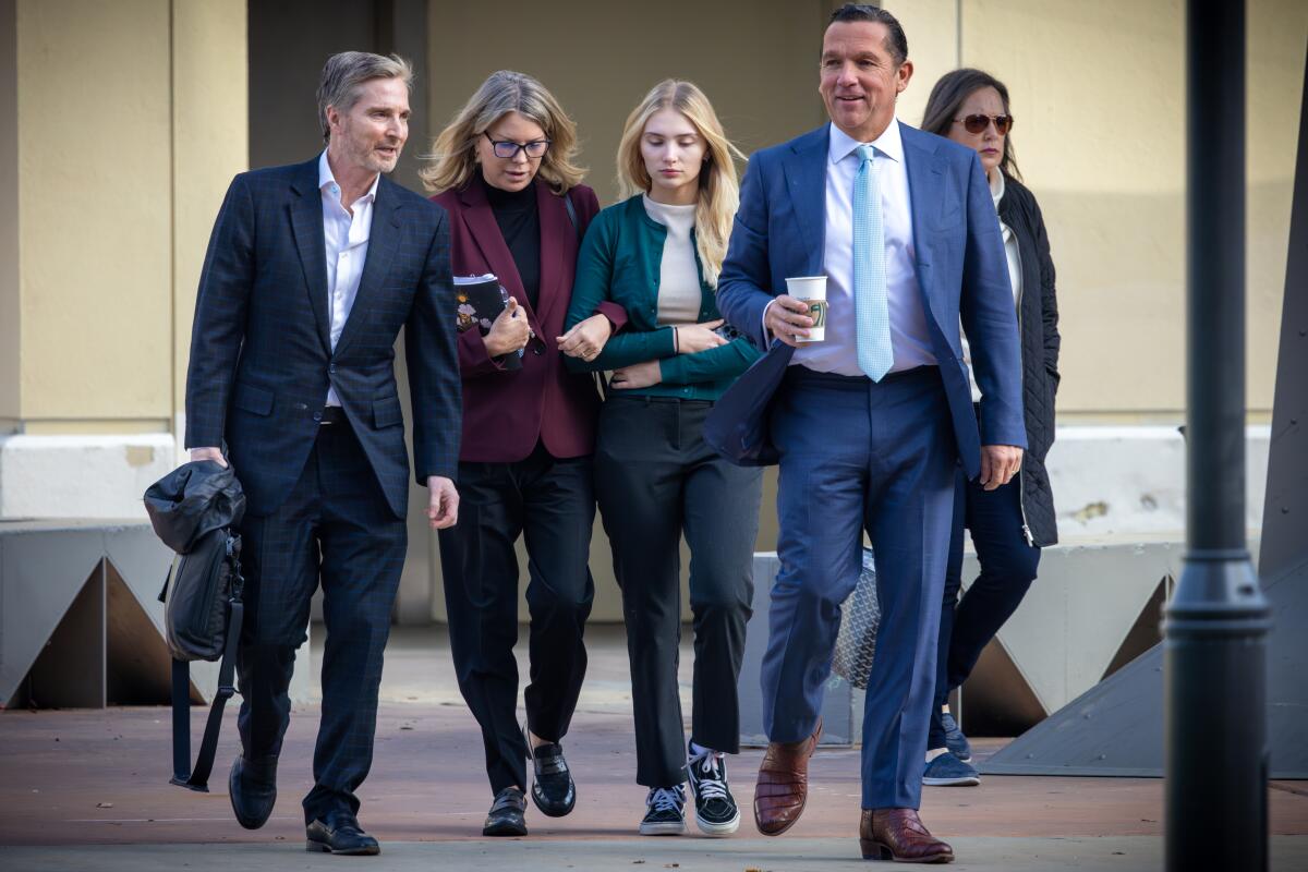 Rebecca Grossman, second from left, walks into court with her husband, Dr. Peter Grossman, left, and daughter, Alexis. 