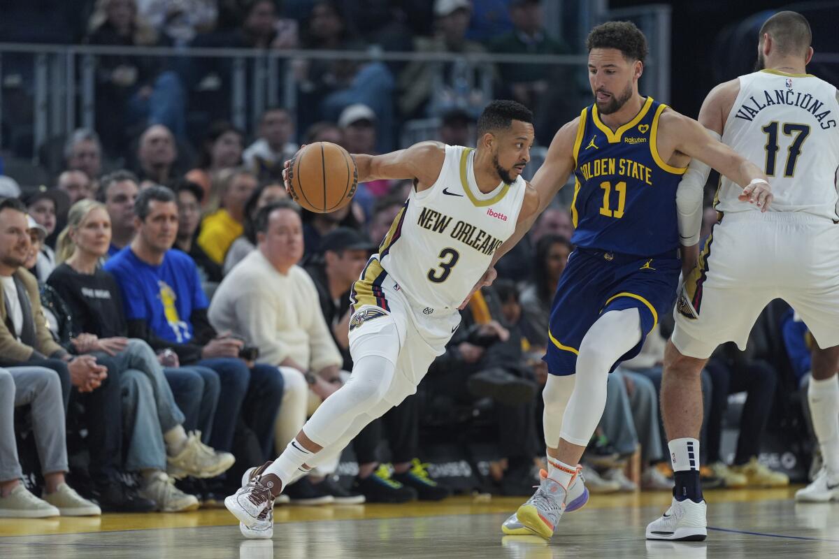 New Orleans Pelicans guard CJ McCollum, left, moves the ball while defended by Golden State Warriors guard Klay Thompson (11) during the first half of an NBA basketball game Friday, April 12, 2024, in San Francisco. (AP Photo/Godofredo A. Vásquez)