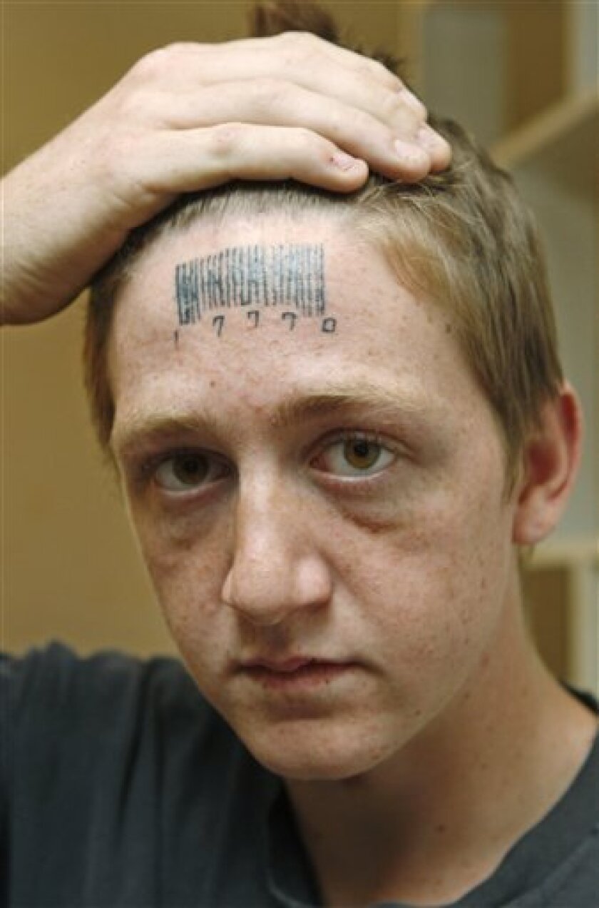 Stetson Johnson, 18, holds back his hair to show a tattoo on his forehead in his home in Oklahoma City, Wednesday, May 4, 2011. The bar code on his forehead hides the word "rapest" which Johnson said Wednesday that attackers forcibly tattooed on his forehead, and he had the bar code tattooed over it in an attempt to hide it. The numbers are three 7s for lucky 7 and 10 for 2010. (AP Photo/Sue Ogrocki)