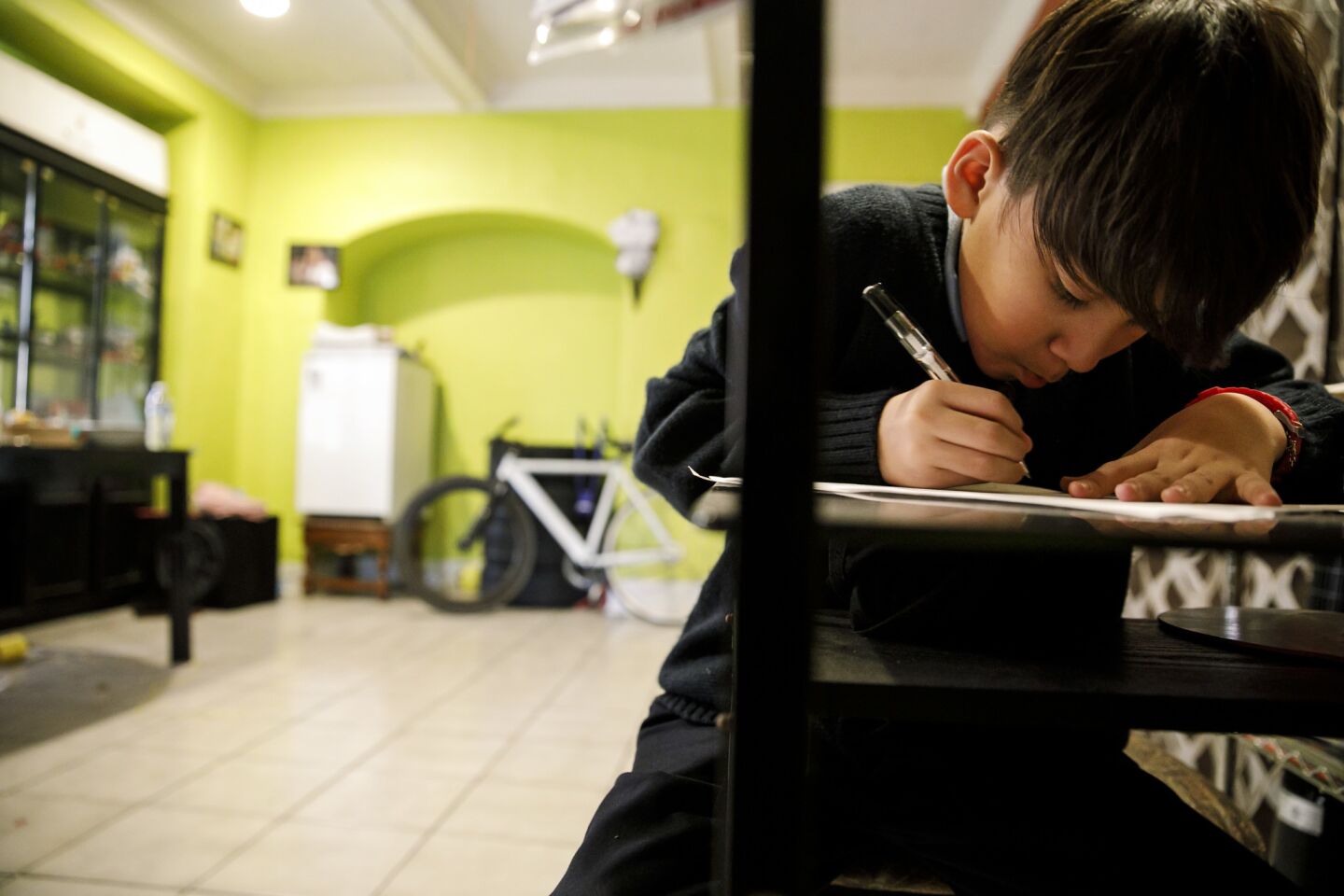 Merwinn Rojas, a Foshay Learning Center sixth-grader, works on his homework on Jan. 8. His mother worries he might regress if teachers go on strike.