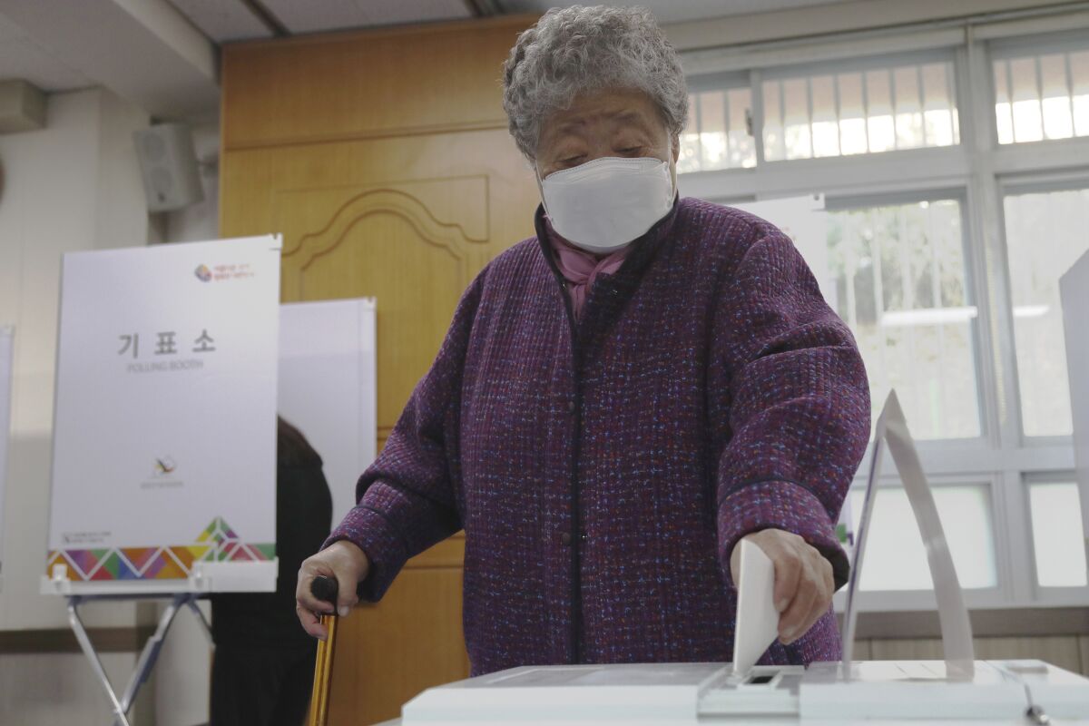 A woman casts her vote at a polling station in Busan, South Korea.
