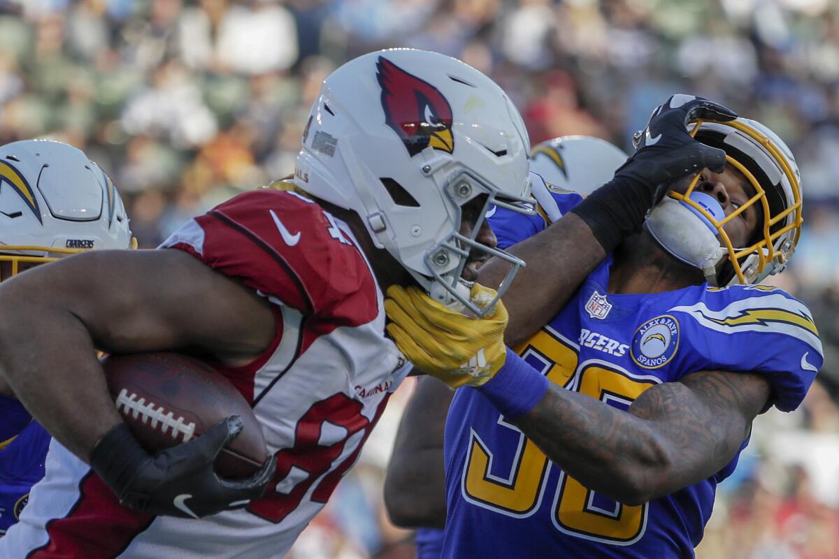 Chargers safety Derwin James wrestles with Arizona Cardinals tight end Jermaine Gresham during third-quarter action at StubHub Center on Sunday.