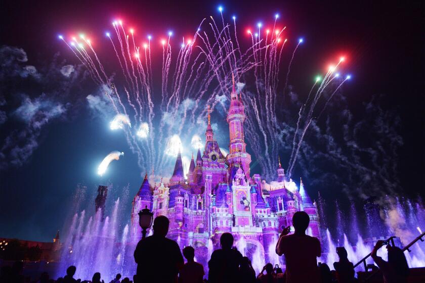 TOPSHOT - This photo taken on June 16, 2017 shows visitors watching fireworks exploding over the castle at an event to mark the first anniversary of the opening of Shanghai Disneyland, in Shanghai. / AFP PHOTO / STR / China OUT (Photo credit should read STR/AFP/Getty Images)