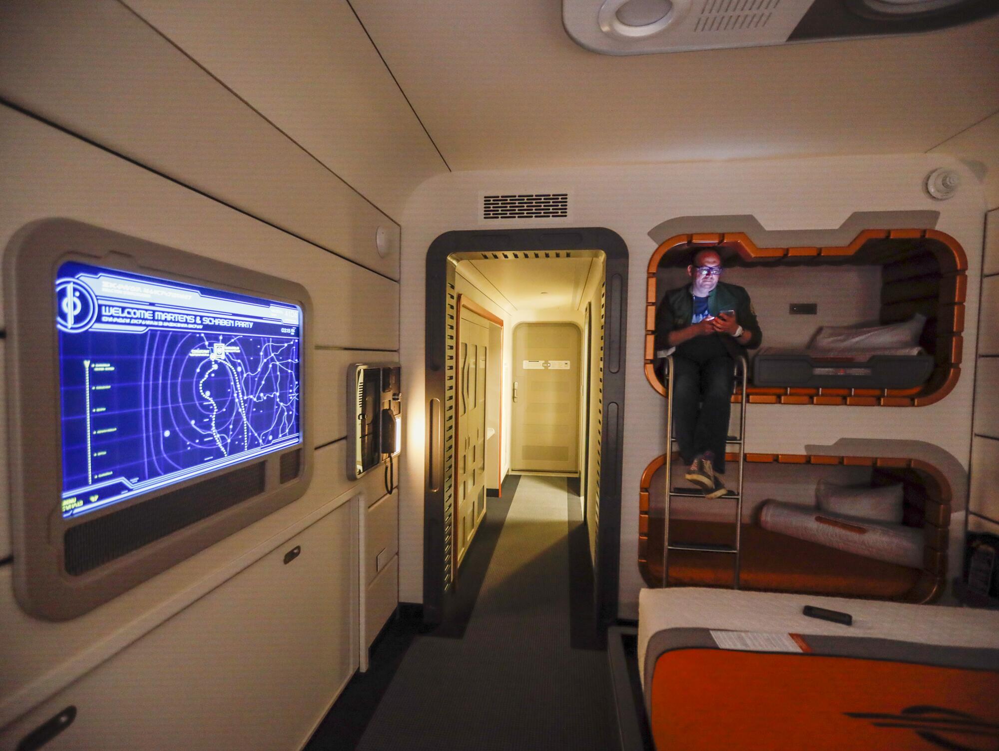 Martens sits in one of the bunk beds inside a standard room aboard the Galactic Starcruiser.
