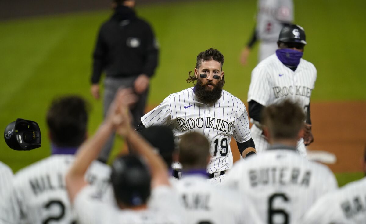 The Rockies' Charlie Blackmon nears waiting teammates after hitting a walk-off grand slam Sept. 11, 2020.