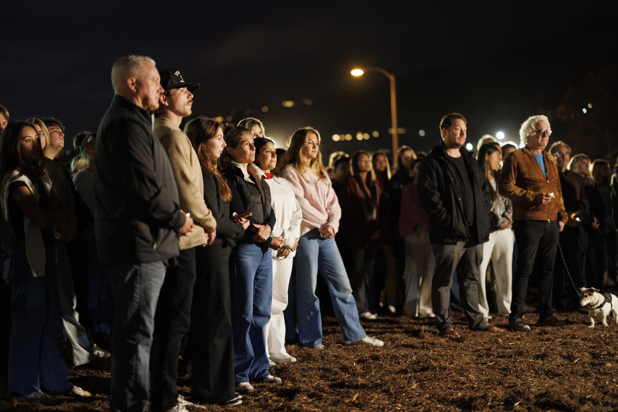 People gather for a vigil for the four Pepperdine students killed one year ago on Pacific Coast Highway in Malibu