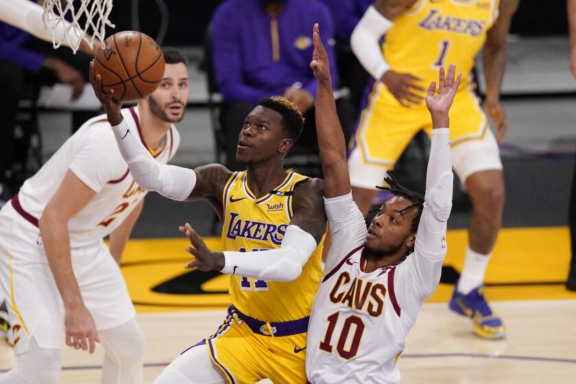 The Lakers' Dennis Schroder goes up for a shot as the Cleveland Cavaliers' Darius Garland defends March 26, 2021.