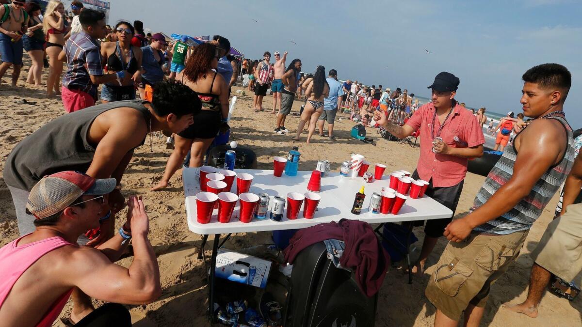 People play beer pong while partying and celebrating on the beach at Clayton's Beach Bar and Grill in South Padre Island, Texas, on March 11.