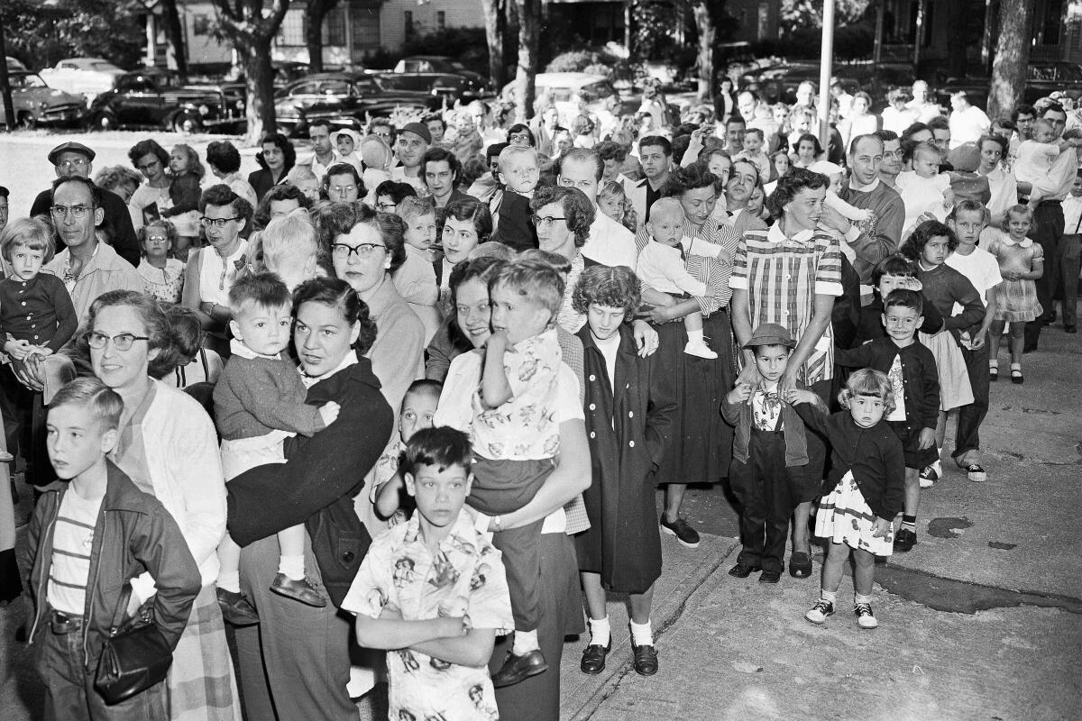 ARCHIVO - Padres y niños esperan afuera de la Escuela Pública Riverside en Elmira, Nueva York,