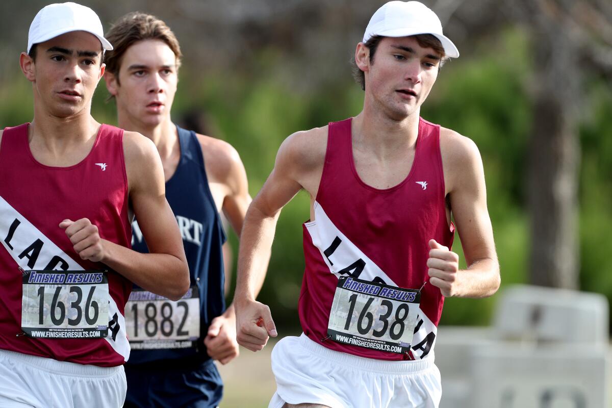 Laguna Beach's Logan Brooks, right, and Mateo Bianchi, left, run in the combined race of the Sunset Conference final at Central Park in Huntington Beach on Nov. 2. Brooks finished first and Bianchi second.
