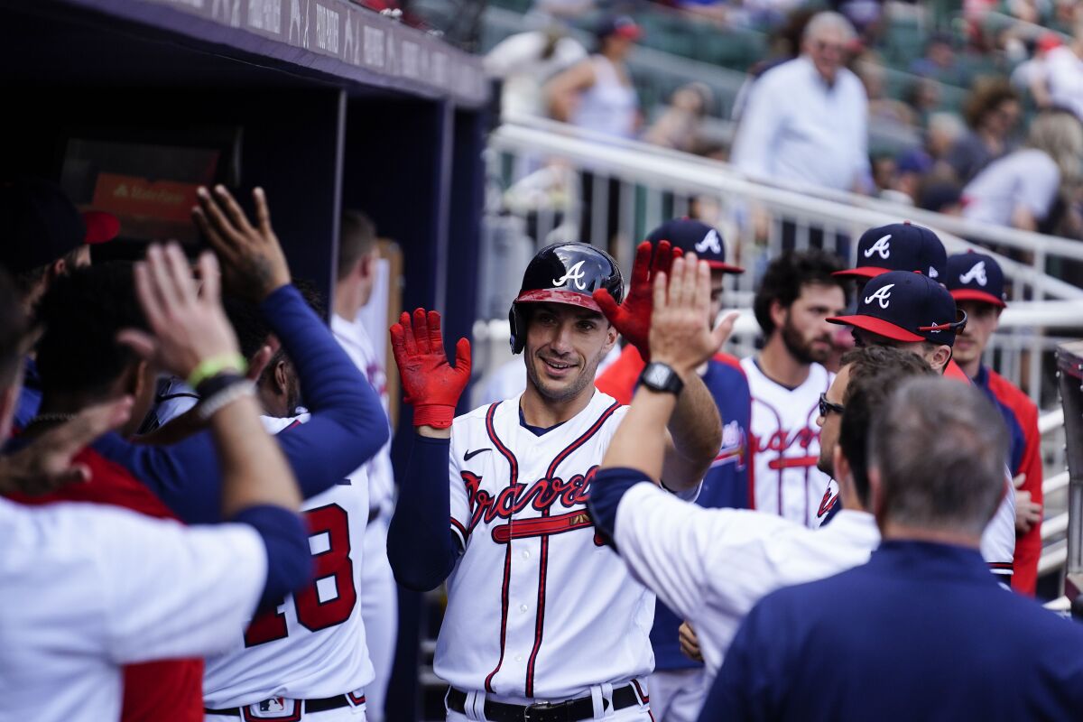 Atlanta Braves' Matt Olson, center, celebrates in the dugout after a home run in the first inning of a baseball game against the San Diego Padres, Saturday, May 14, 2022, in Atlanta. (AP Photo/Brynn Anderson)