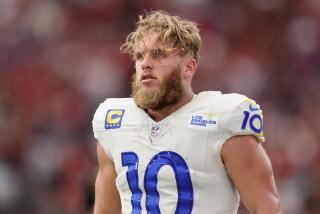 Rams receiver Cooper Kupp stands on the sideline with his helmet off.