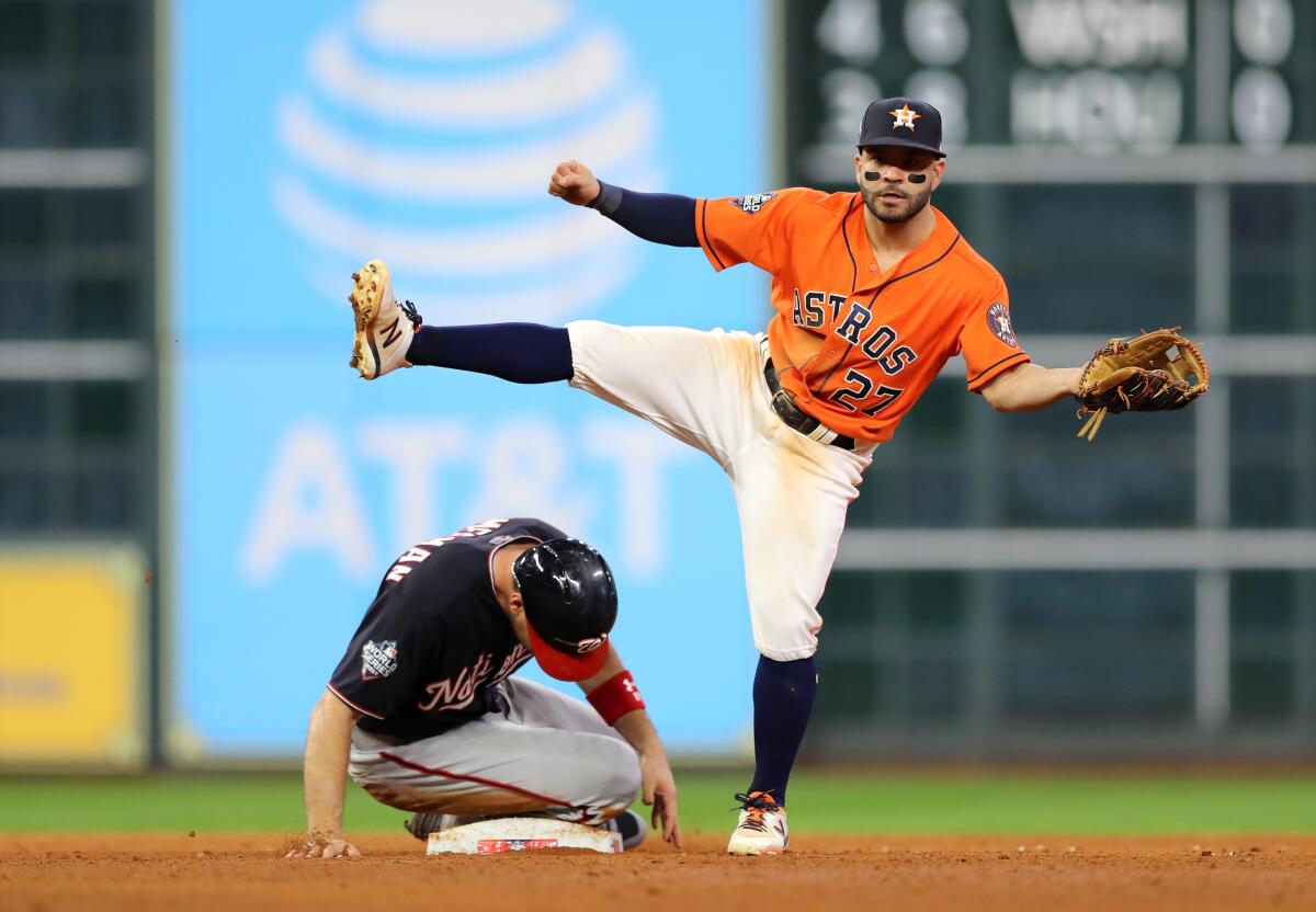 Astros second baseman Jose Altuve gets a force out on Nationals first baseman#Ryan Zimmerman during Game 7 of the 2019 World Series at Minute Maid Park.