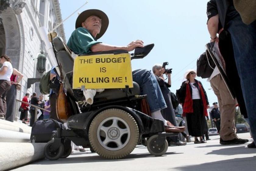 In San Francisco, a man in a wheelchair protests proposed budget cuts.
