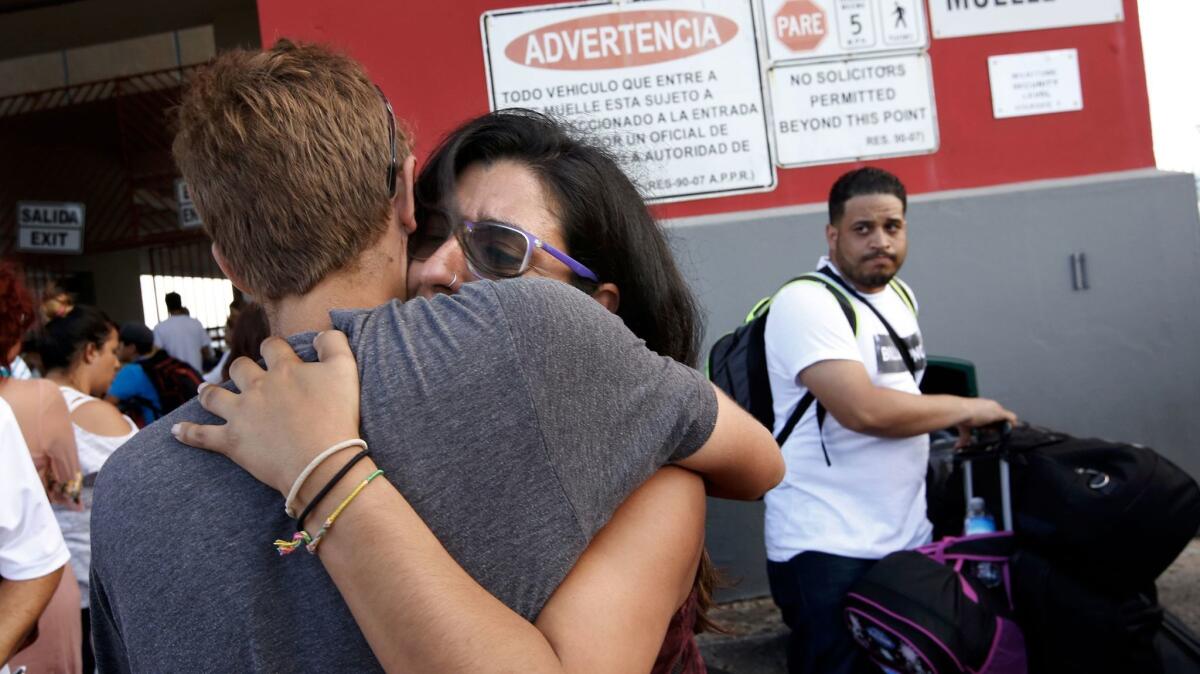 Alejandra Suarez, 30, cries as she embraces her husband, Javier Munoz, on the pier Thursday in San Juan, Puerto Rico.