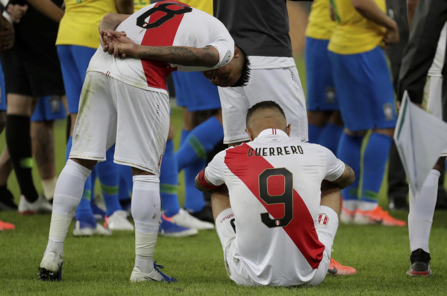 Peru's Christian Cueva, left, leans over to console Paolo Guerrero after losing the final Copa America soccer match to Brazil at Maracana stadium in Rio de Janeiro, Brazil, Sunday, July 7, 2019. Brazil won 3-1.