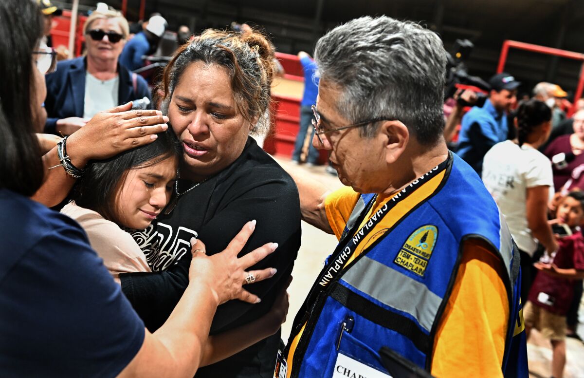 A teacher consoles one of her students after a vigil for shooting victims in Uvalde, Texas, on Wednesday