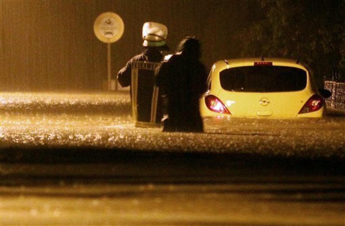 A fireworker makes his way through the waters to reach a flooded car in Goerlitz Eastern Germany late Saturday Aug. 7, 2010. Police say heavy rain has caused flooding that killed three people in the eastern German state of Saxony after they were trapped in their basement. (AP Photo/dapd/Sebastian Willnow)