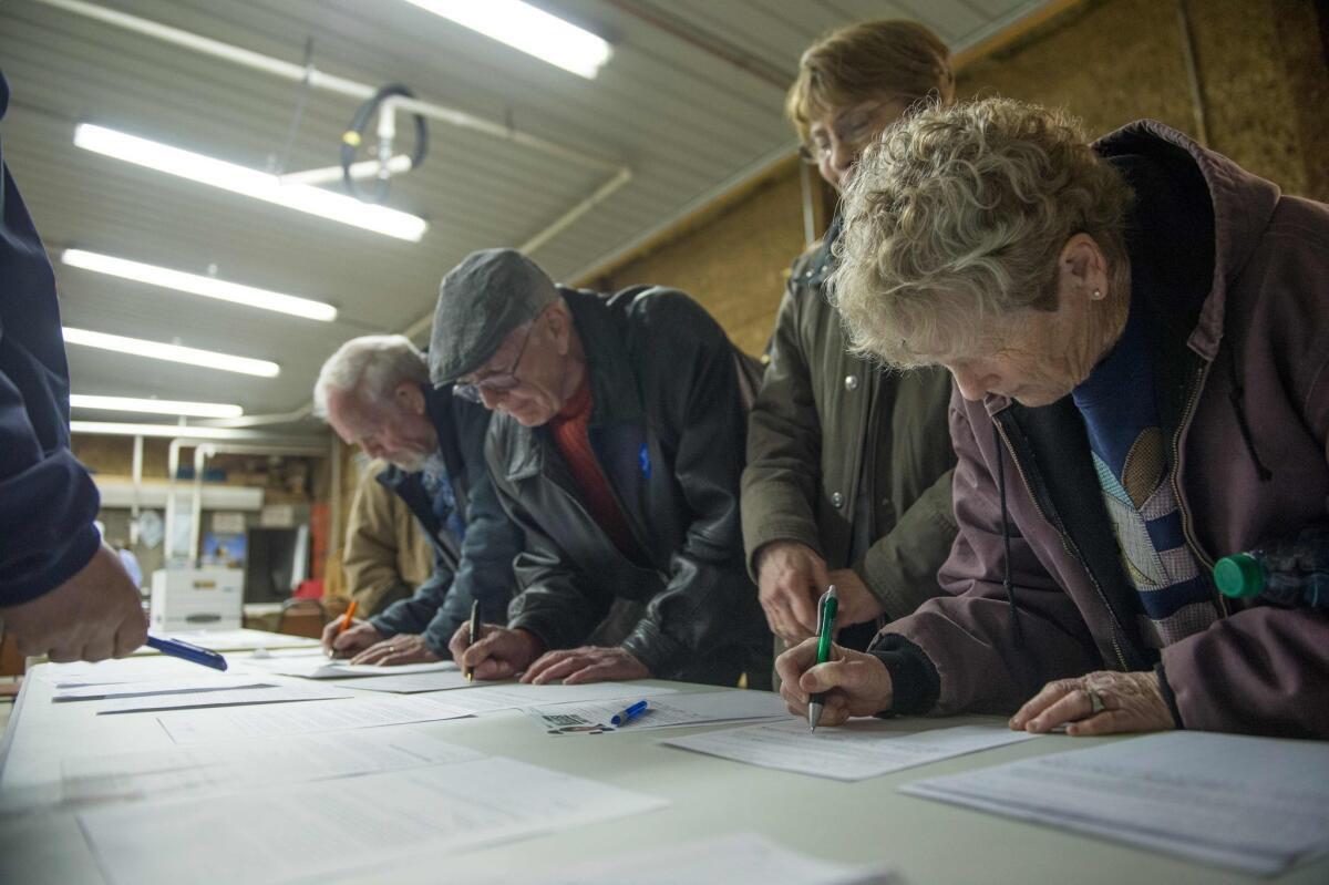 Voters sign in as they arrive at a Democratic Party caucus site in Keokuk, Iowa, on Saturday. The state kicks off the nominating process for both the Democratic and Republican presidential nominee, and this year, the Iowa Democratic Party is hosting remote caucuses to allow Iowans who are out of state to vote.