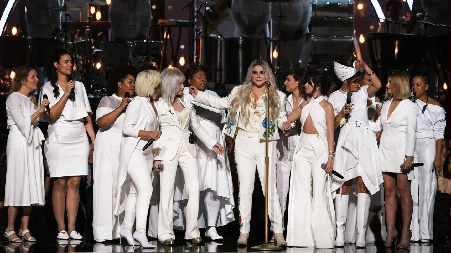 Kesha, center, flanked by her collaborators onstage at the 2018 Grammys.