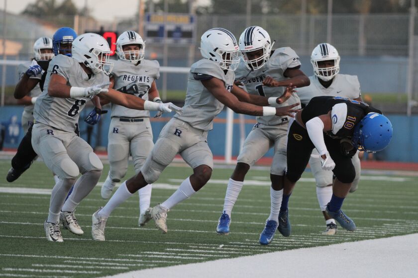 LOS ANGELES, CA - APRIL 9, 2021: Five Reseda defenders team up to force Crenshaw wide receiver Centrell Wise (10) out of bounds in the first half at Crenshaw High School on April 9, 2021 in Los Angeles, California.(Gina Ferazzi / Los Angeles Times)