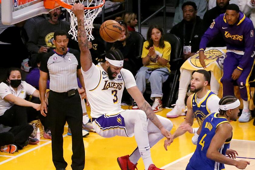 Los Angeles, CA - May 06: Lakers power forward Anthony Davis hangs on the rim after throwing down a dunk.