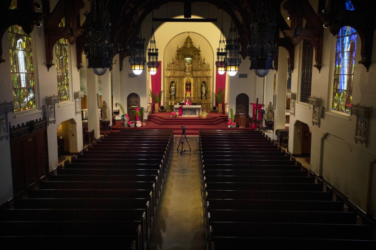 Fr. Joe O'Neill gives Mass during the coronavirus pandemic at Holy Family Church in South Pasadena on April 5, 2020. Normally, the church would be filled with parishioners on Palm Sunday. The church says more than 10,000 visitors tuned into their livestreamed Masses.