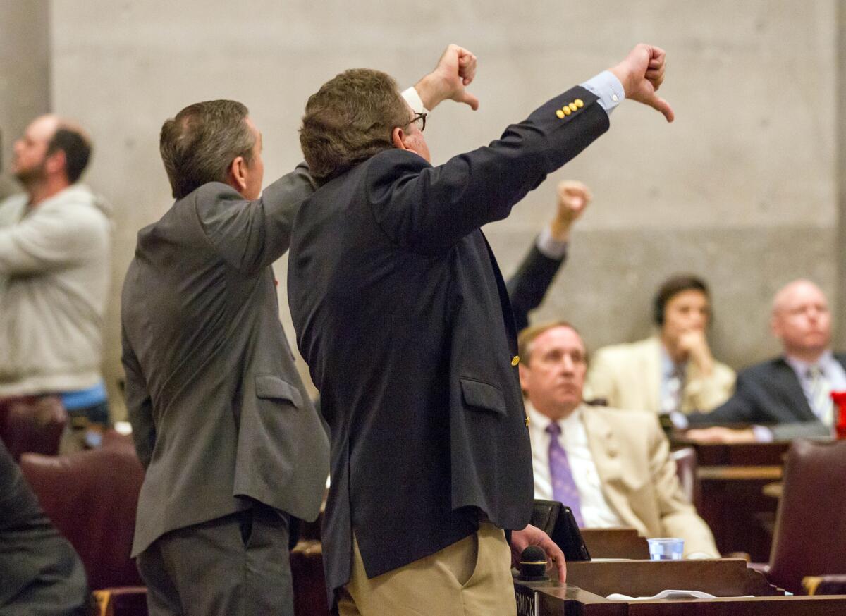 House Majority Leader Gerald McCormick (R-Chattanooga) right, and House Republican Caucus Chairman Glen Casada of Franklin signal to colleagues on the House floor in Nashville on April 6 during a debate about a bill to allow counselors to refuse treatment of patients based on personal beliefs.