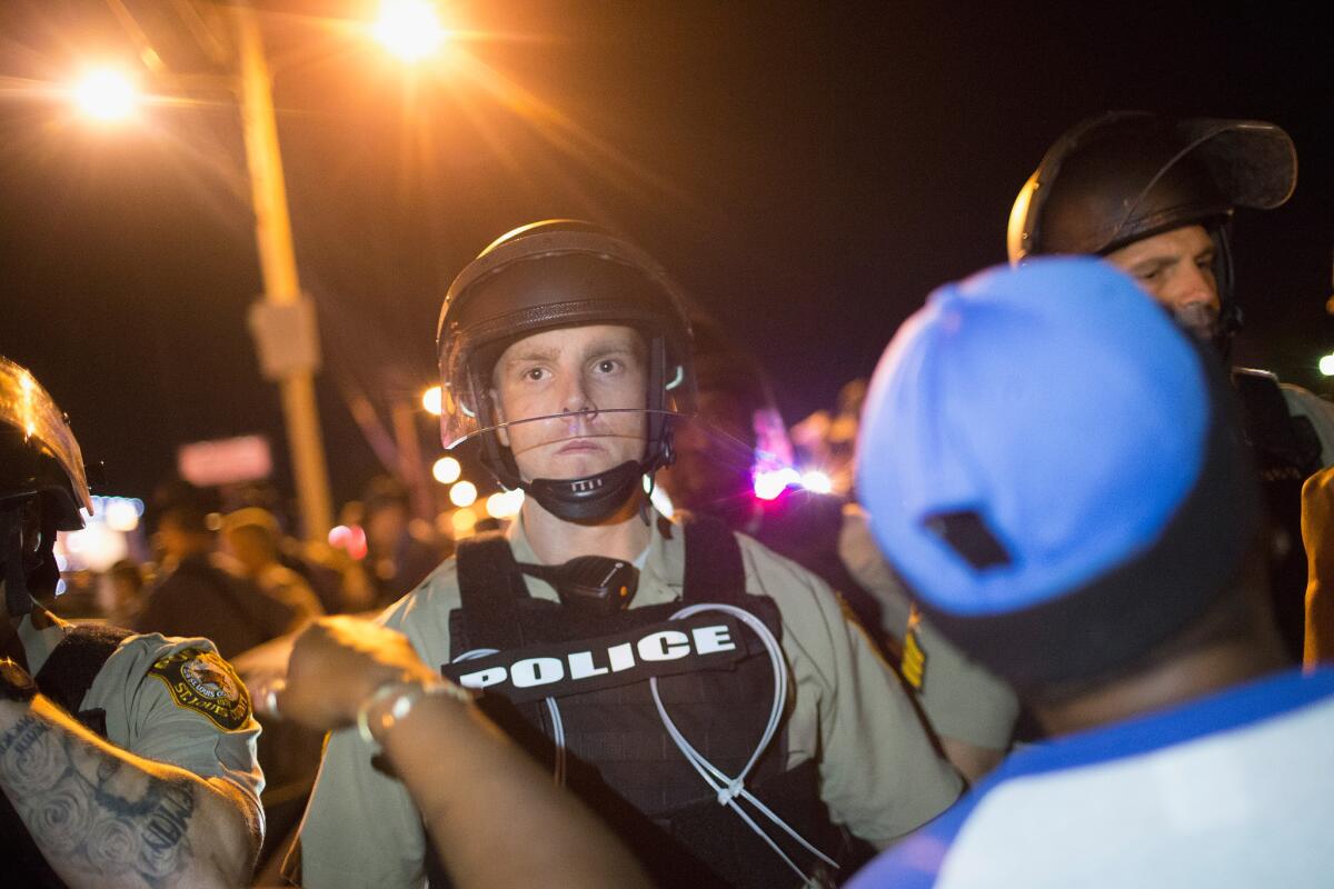 Demonstrators marking the anniversary of the shooting of Michael Brown confront police along West Florrisant Street on Aug.11, 2015, in Ferguson, Mo.