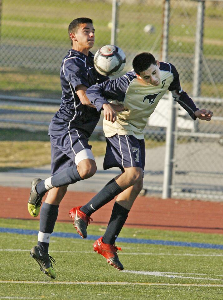 Muir's Alex Tapia wins the mid-air header against Crescenta Valley's Shyan Chachi in the first half in a Pacific League soccer match at Muir High School in Pasadena on Friday, January 4, 2013.