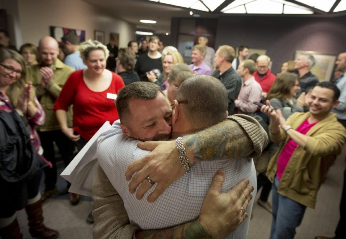 Chris Serrano, left, and Clifton Webb embrace after being married in Salt Lake City on Friday.