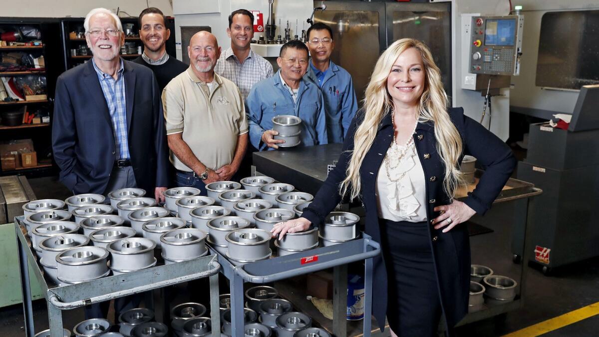 Robin Follman-Otta, right, chief executive of R.A. Industries LLC. in Santa Ana, with, from left, her father, founder and chairman Robert Follman, Production Manager Randal Leach, General Manager Walt Leach, Chief Operating Officer Brian Goodman, and Mai Tai and Phung Le.