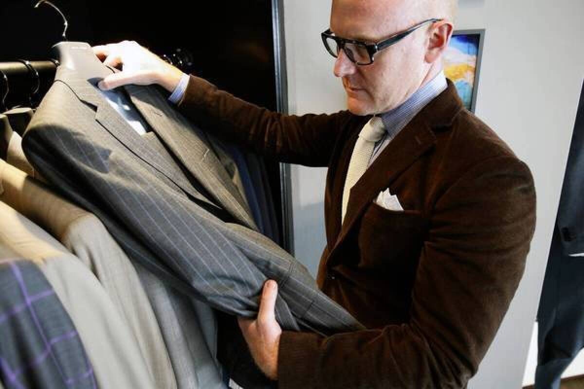 Seize sur Vingt owner James Jurney pulls out one of his suits. They make bespoke shirts and suits.