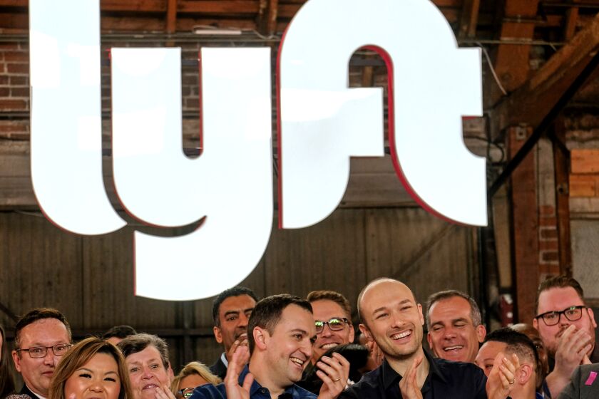 Lyft co-founders John Zimmer, left, and Logan Green cheer as they ring a ceremonial opening bell in Los Angeles, Friday, March 29, 2019. On Friday the San Francisco company's stock will begin trading on the Nasdaq exchange under the ticker symbol "LYFT." (AP Photo/Ringo H.W. Chiu)