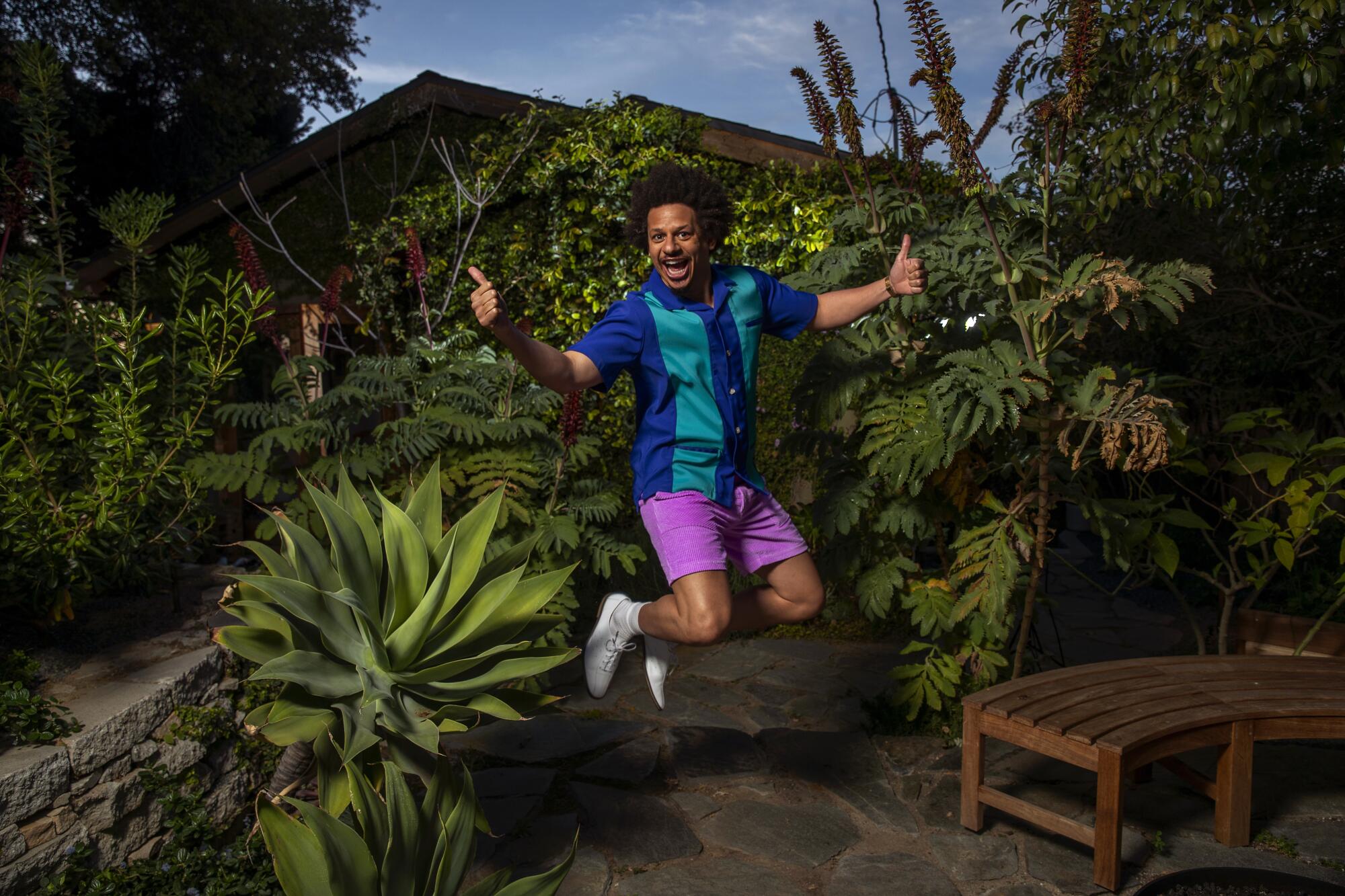 Eric Andre gives double thumbs-up as he jumps in the air