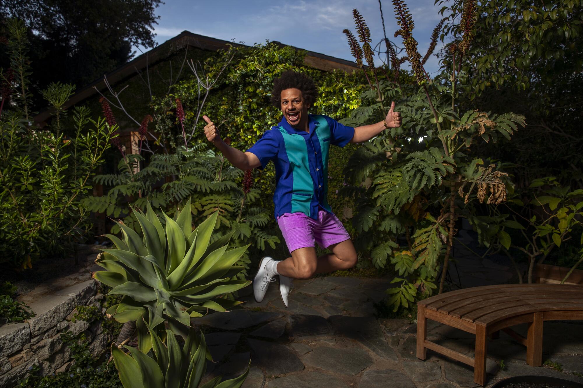 Eric Andre gives double thumbs-up as he jumps in the air