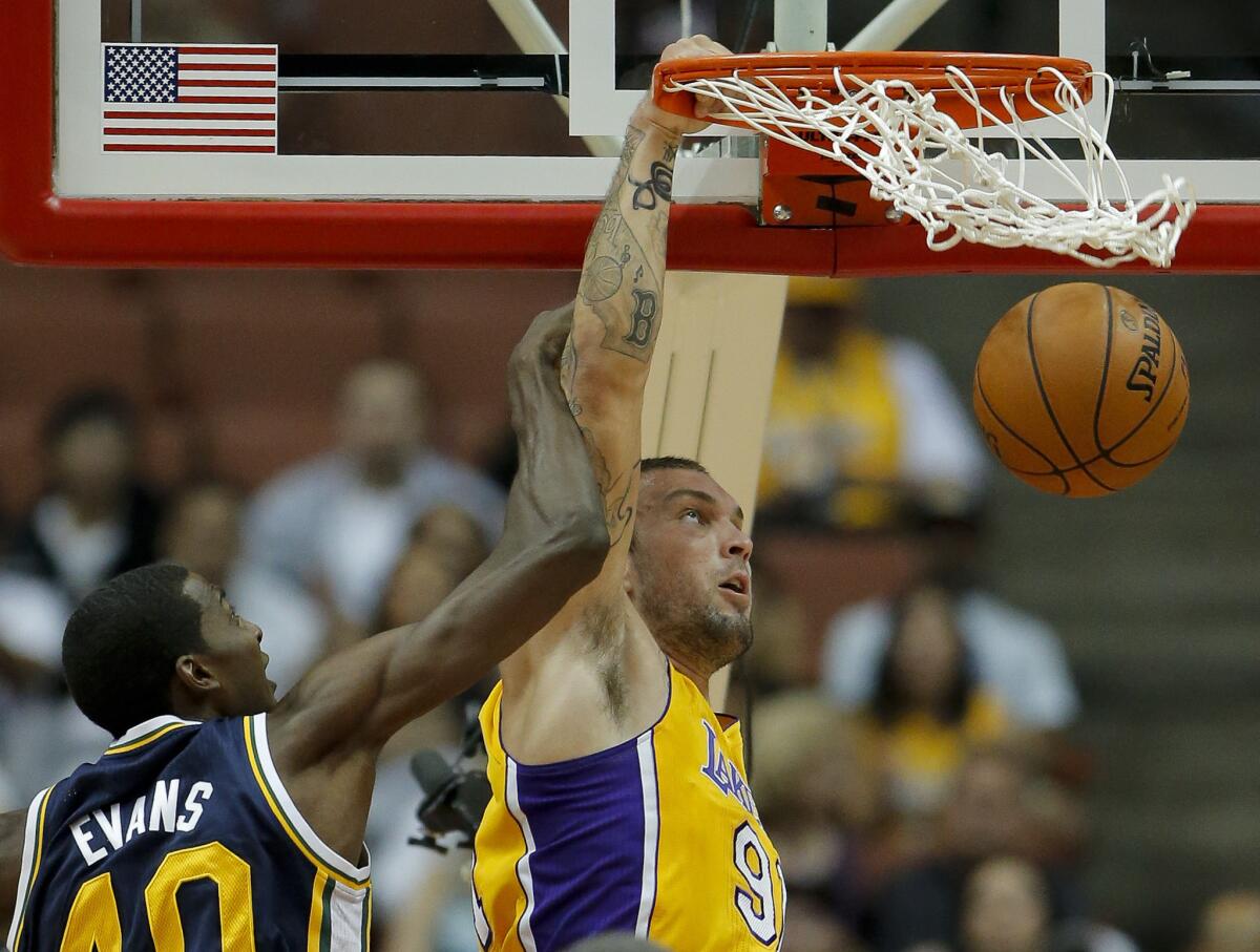 Lakers forward Reeves Nelson dunks against Jazz forward Jeremy Evans in an exhibition game Tuesday.