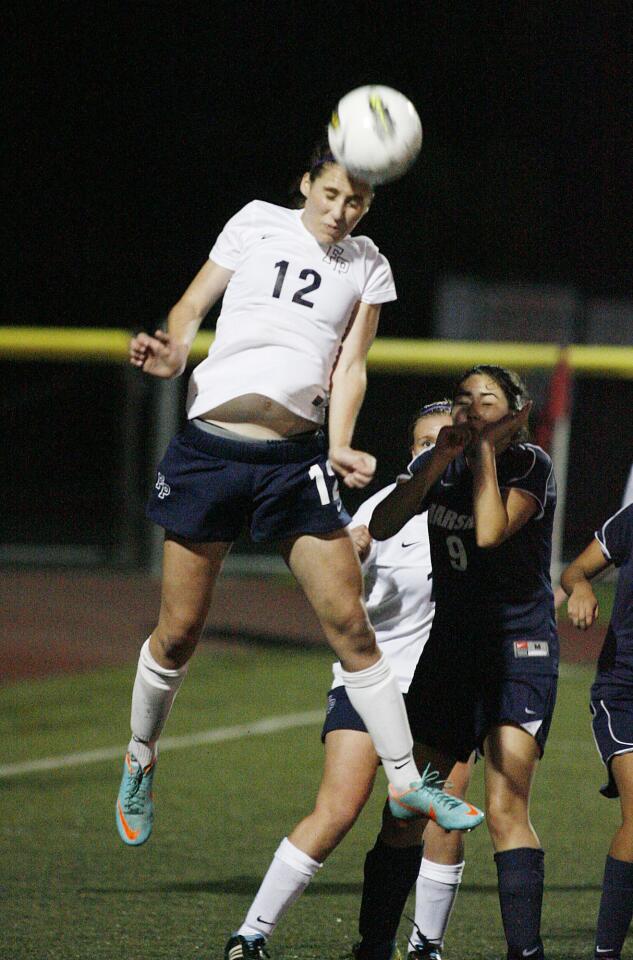 Flintridge Prep's Whitney Cohen jumps highest to head a corner kick clear of her goal against Marshall Fundamental at the Glendale Sports Complex in a non-league girls soccer match on Friday, November 30, 2012.