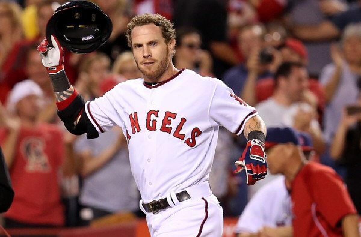 Angels designated hitter Josh Hamilton removes his helmet as he arrives at home plate to begin celebrating his walk-off home run against the Astros on Saturday night.