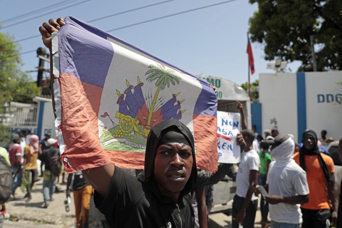 A demonstrator holds up a Haitian flag during a protest in Port-au-Prince.