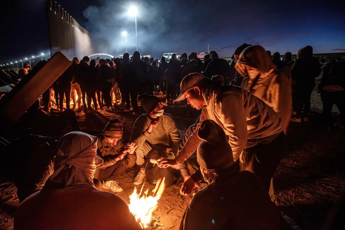 Migrants wait to be processed by Border Patrol agents after crossing from Mexico on Dec. 17 in Yuma, Ariz.