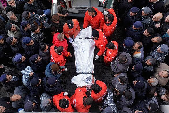 The body of a victim of the Ethiopian Airlines crash is carried into the Rafik Hariri Hospital in Beirut by Lebanese Red Cross workers.