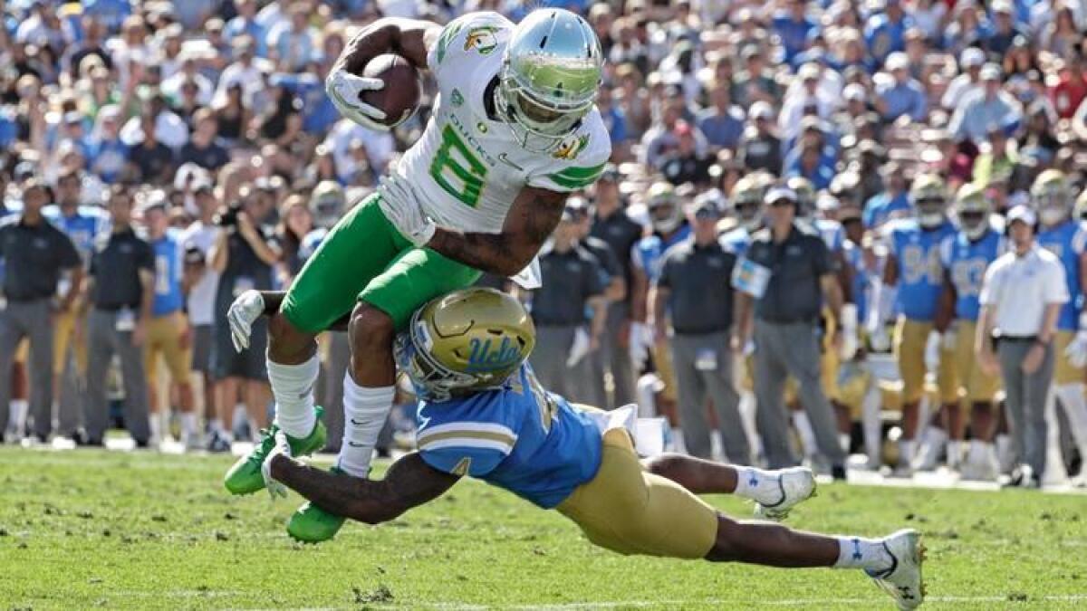 UCLA defensive back Jaleel Wadood tackles Oregon Ducks receiver Charles Nelson in the second quarter Saturday at the Rose Bowl.