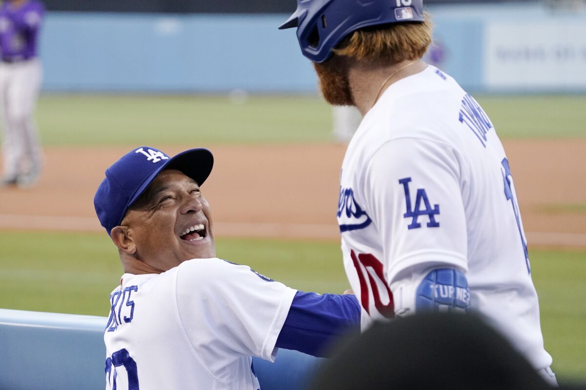 Los Angeles Dodgers' Justin Turner, right, jokes with manager Dave Roberts prior to a baseball game against the Colorado Rockies Friday, July 23, 2021, in Los Angeles. (AP Photo/Mark J. Terrill)